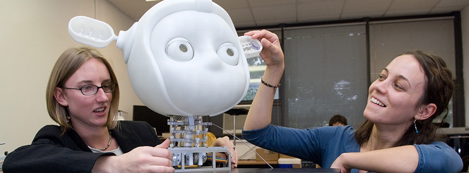 Students examining a robot in the Socially Intelligent Machines Lab